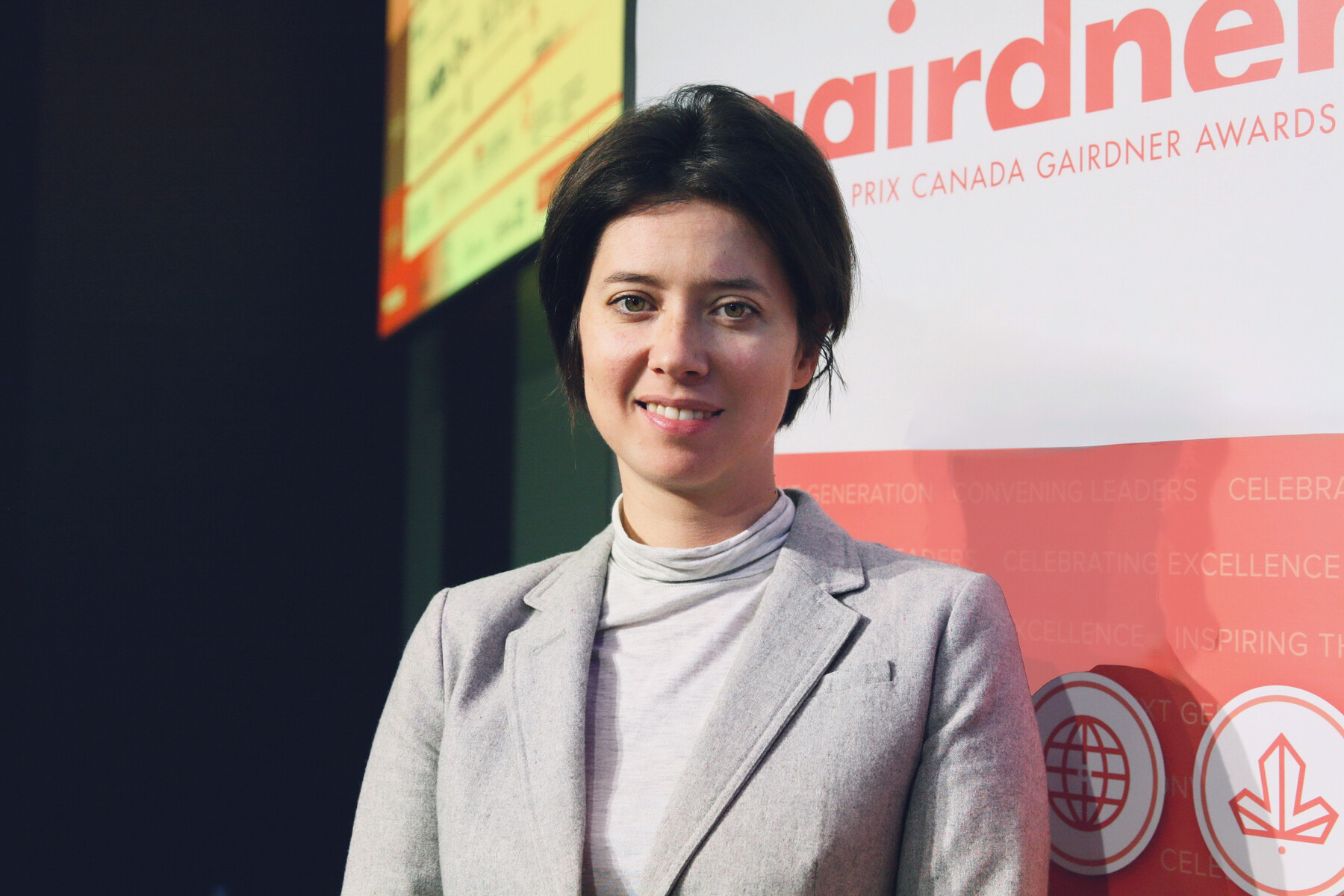 Close-up of Elena Kuzmin in front of Gairdner pull-up banner