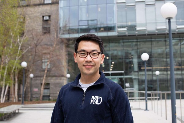 young asian bespectacled man pictured outside the Donnelly Centre