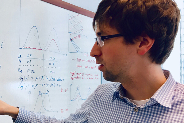 researcher next to a white board