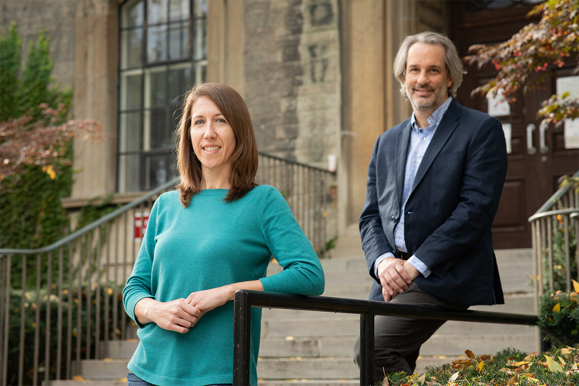 female and male researcher standing outside U of T building