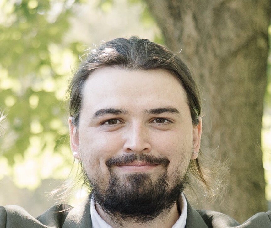 headshot of student, bearded with ponytail