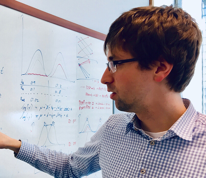 researcher next to a white board