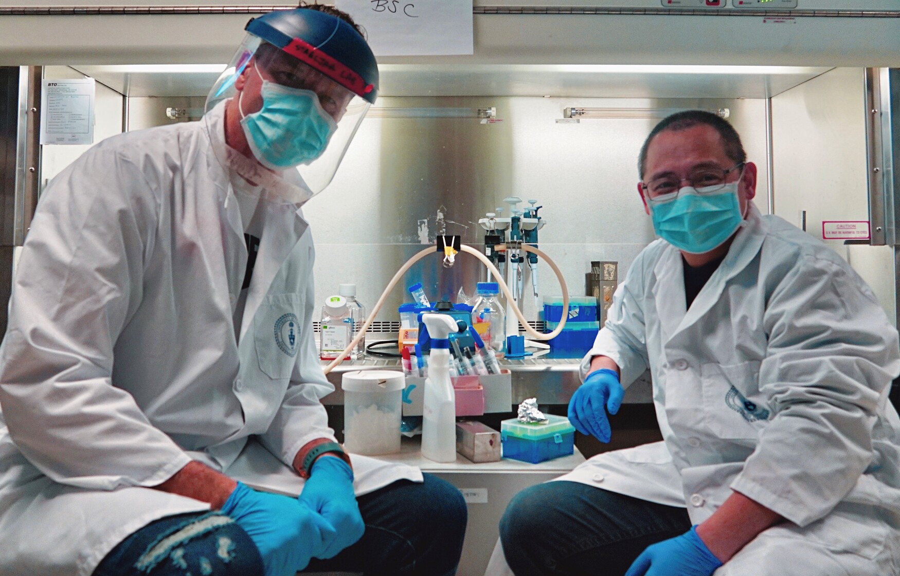 Researchers in the lab wearing protective gear