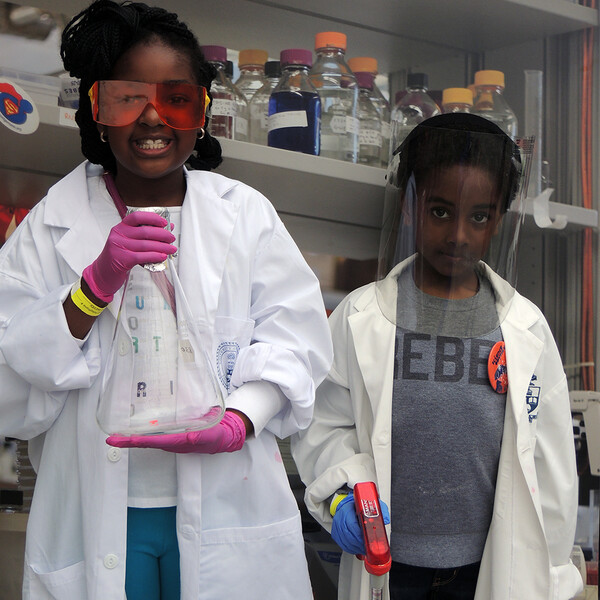 a girl and a boy posing with lab equipment